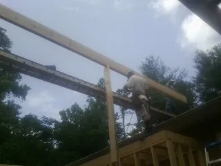 Carpenter setting a ridge beam over a new addition frame — Ice Dam Removal by Roofing Brothers in North Berwick