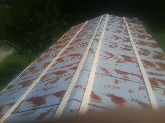 Rusted metal roof panels with new wood purlins before replacement — Storm Damage Roof Repair in North Berwick by Roofing Brothers